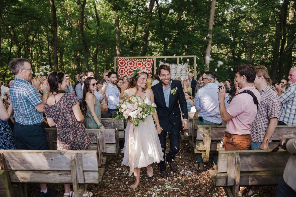 A bride and groom exit their ceremony officially married. All of their guests are cheering for them with excitement. how to legally get married in pennsylvania