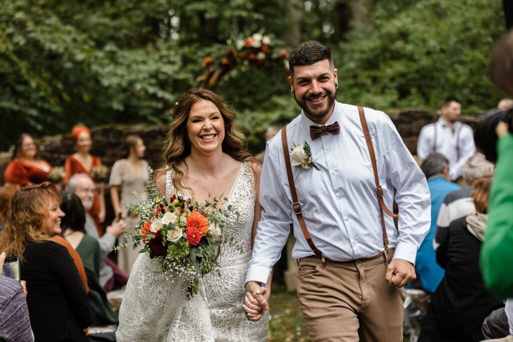 A bride and groom are all smiles as they leave their wedding ceremony officially married. They are both beaming with joy. how to legally get married in pennsylvania