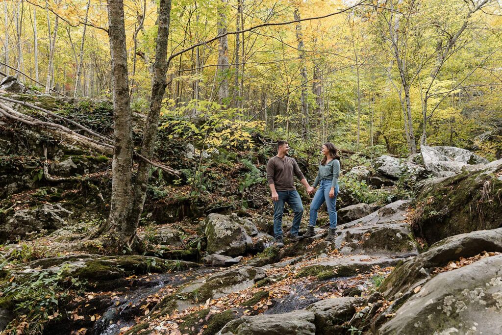 A couple stands at Dark Hollow Falls in Shenandoah National Park after a hike on their elopement day. Shenandoah Fall Colors