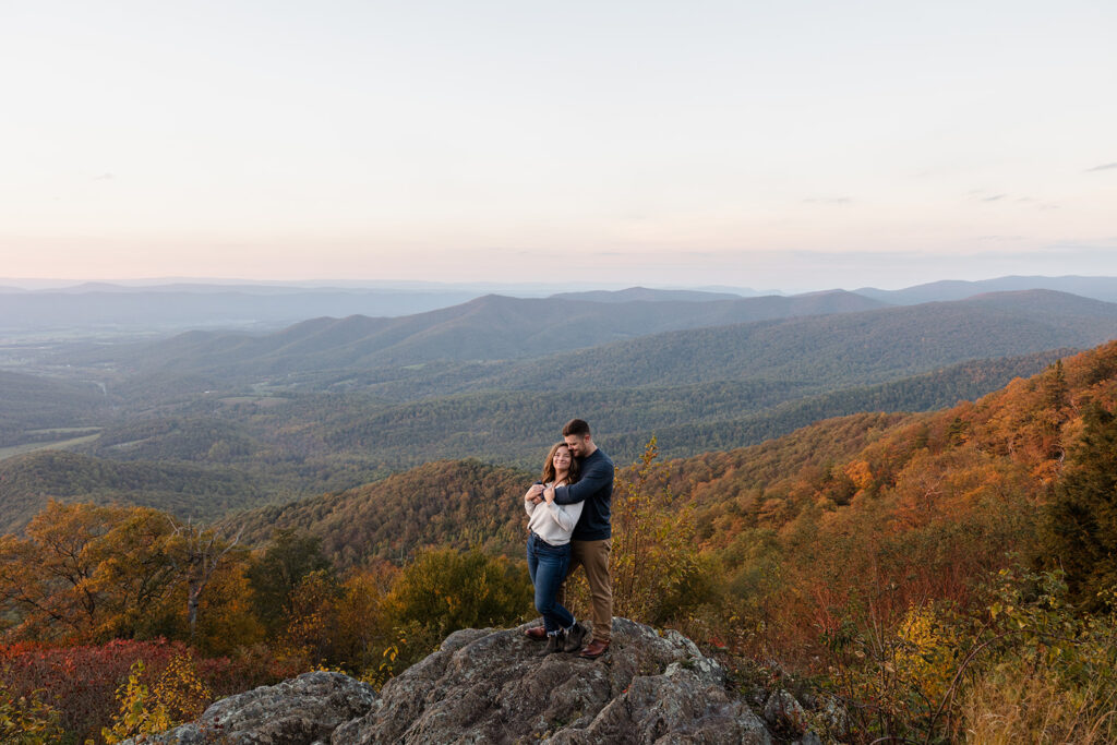 A couple snuggles at an overlook on Skyline Drive after their elopement. Shenandoah Fall Colors