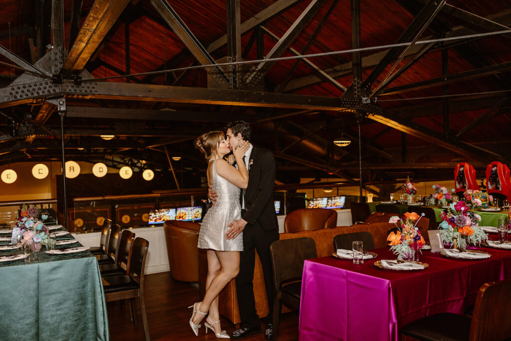 A birde and groom kiss in the middle of their reception set up. 