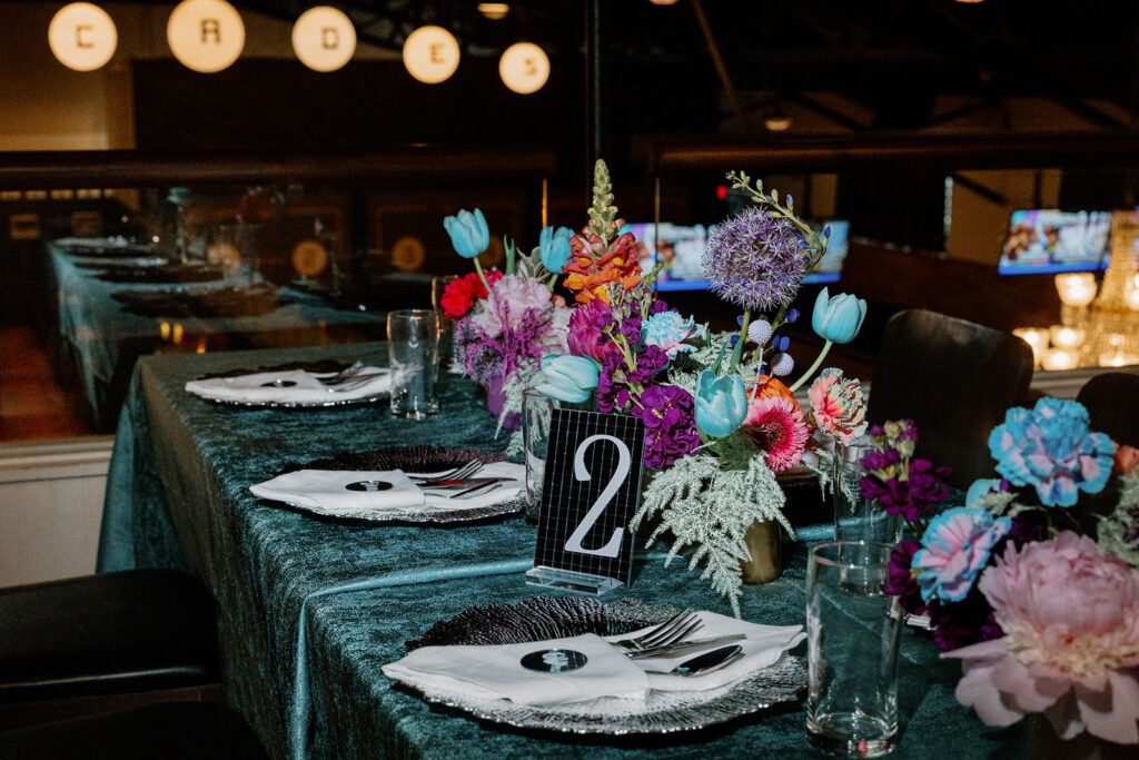 A bright, bold, and fun tablescape at an elopement reception at a vintage arcade.  