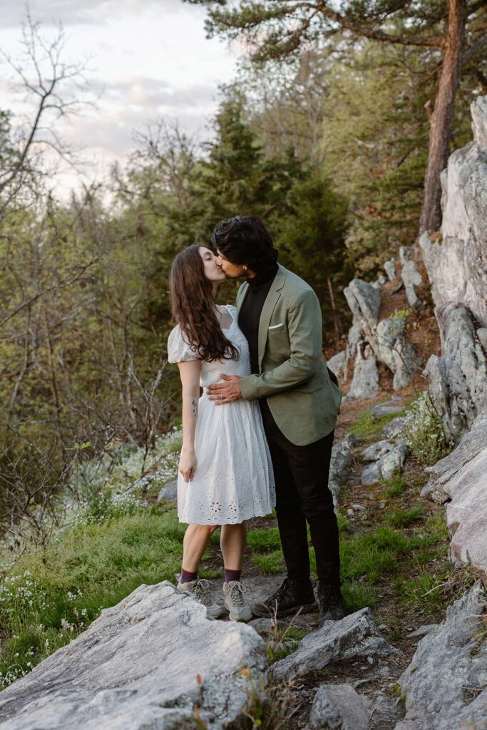 A bride and groom stop to kiss during their sunrise elopement
