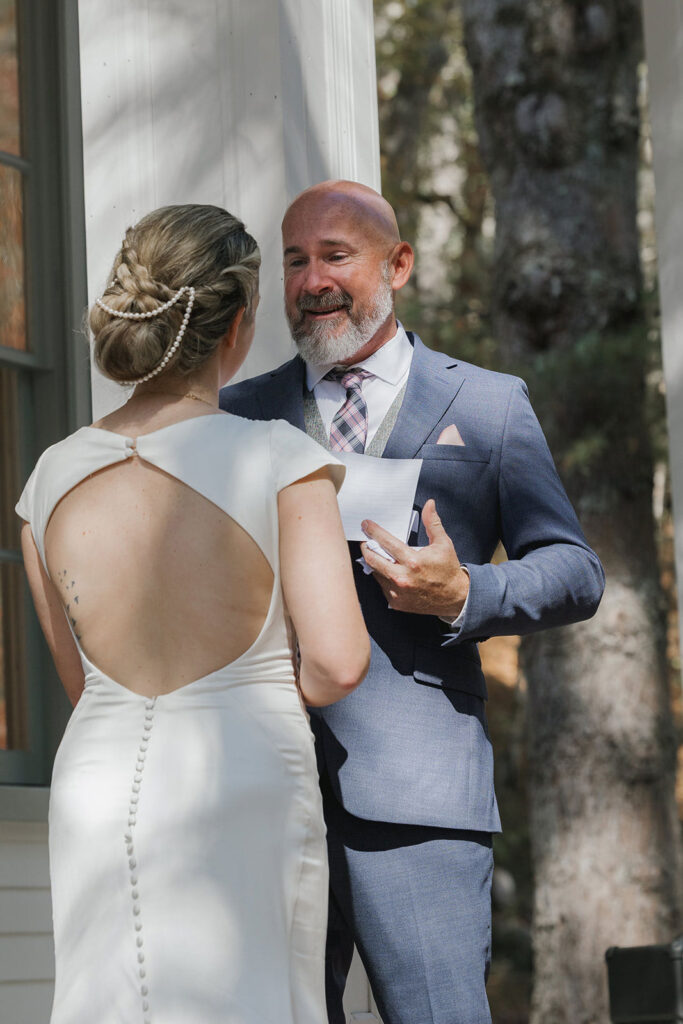 A groom tears up reading his vows to his bride on their wedding day