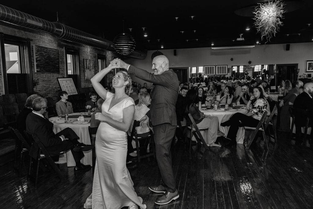 A groom spins his wife during the first dance on their wedding day