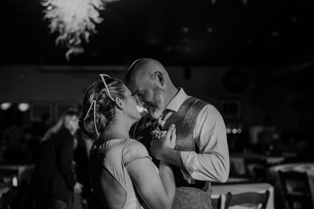 A black and white photo of a couple sharing an intimate first dance at their wedding