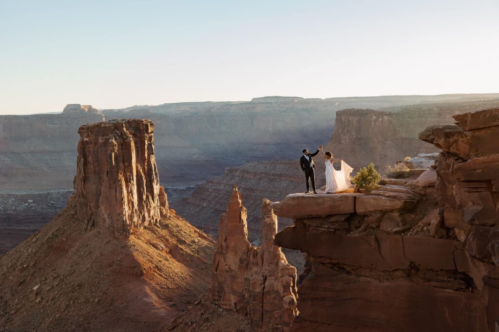A groom twirls his bride at an overlook at Marlboro Point elopement as the sunsets.