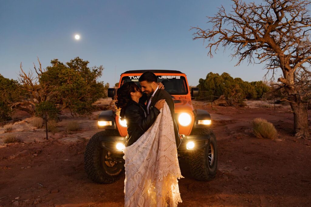 A bride and groom share their first dance under a super moon and the headlights of their jeep during their jeep adventure elopement at marlboro point