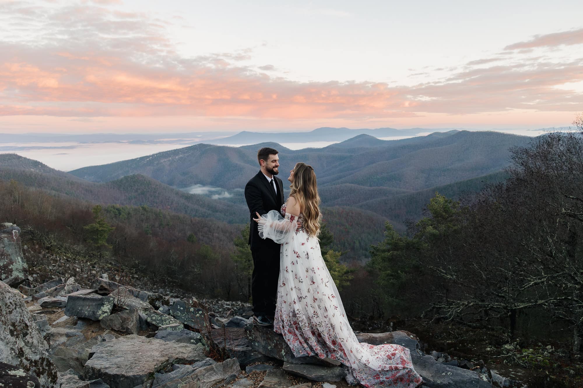 A couple stands facing one another during their sunrise Shenandoah Elopement at Blackrock Summit