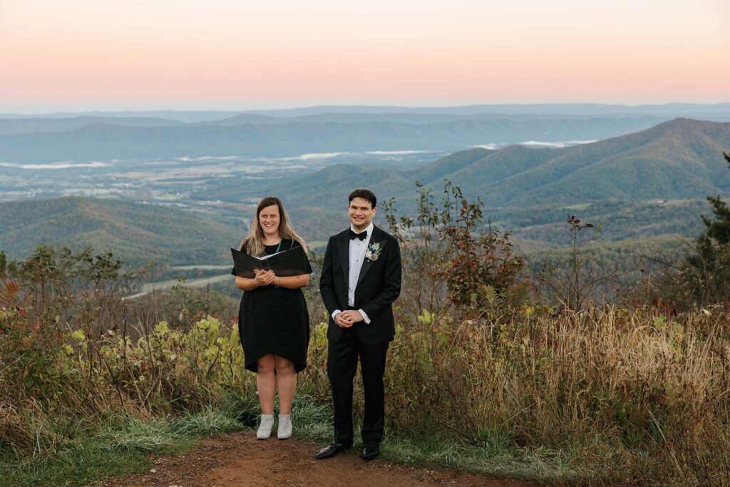A groom and officiant look forward as the bride walks towards them to start the sunrise elopement ceremony at Jewell Hollow Overlook At Shenandoah 