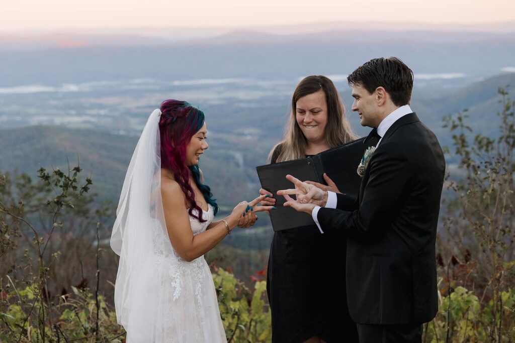 A bride and groom do a round of rock paper scissors to see who will say their vows first at their sunrise elopement in Shenandoah
