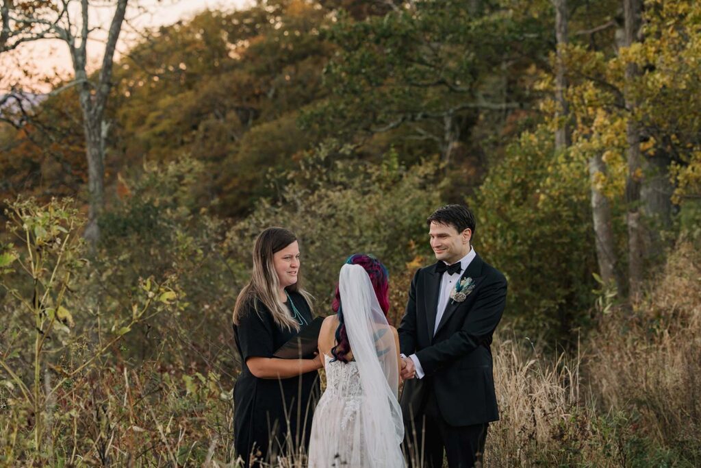 A groom smiling at his bride during their elopement ceremony at Jewell Hollow in Shenandoah