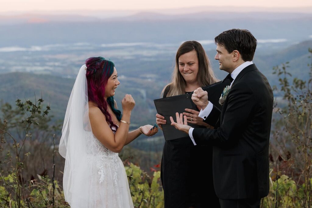 A bride and groom do rock, paper, scissors to decide who is going to say their vows first during their sunrise wedding at Jewell Hollow in Shenandoah National Park