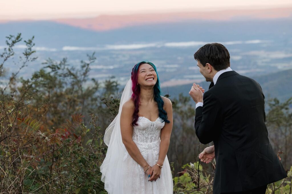 A bride laughs as the groom says his vows to her during their sunrise ceremony at Jewell Hollow Overlook