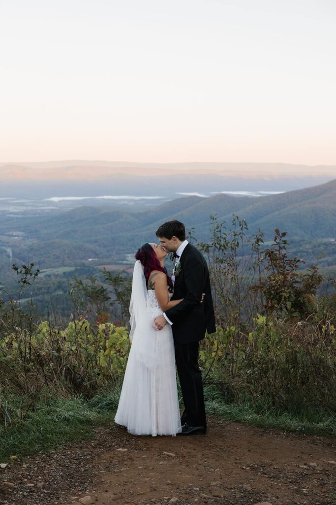 A bride and grooms first kiss during their sunrise adventure elopement at Jewell Hollow Overlook in Shenandoah