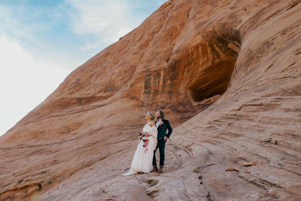 A bride and groom admire the views of the  desert in moab Utah during their adventure elopement. 