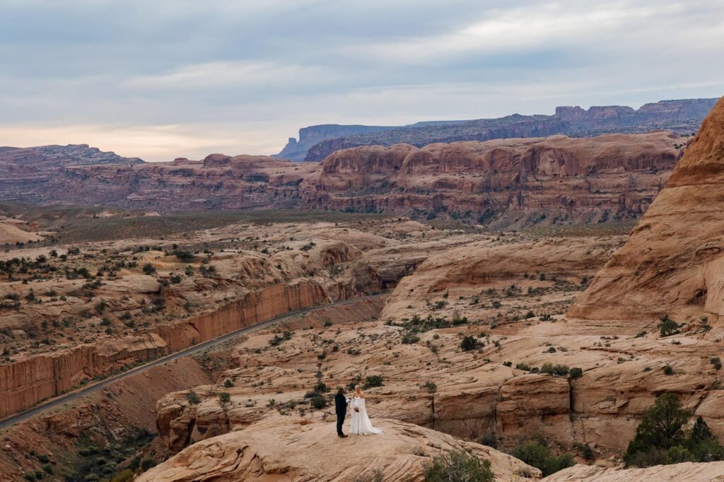 A bride and groom say their vows in front of a stunning vast views of the Moab desert