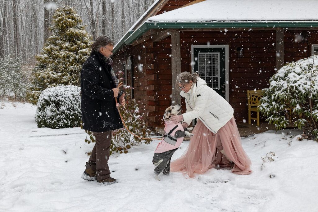 A dog sees her mom, the bride, for the first time on their elopement day. The dog jumps up on the bride with excitement.