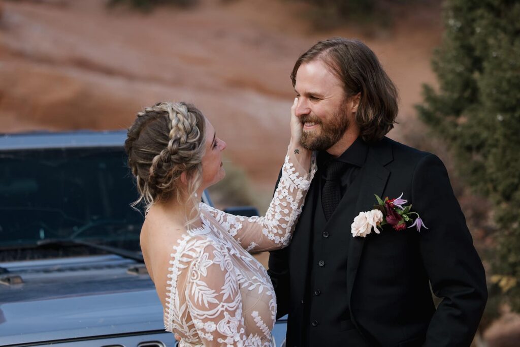 a bride gently touched the cheek of her groom during the first look on their wedding day in Moab