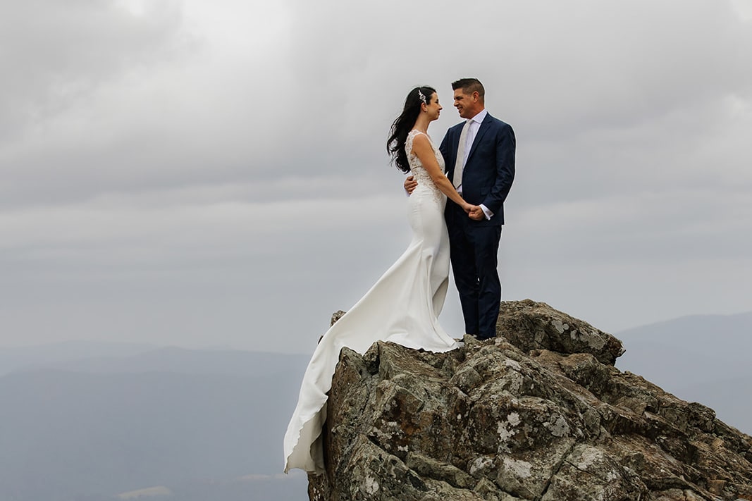 A bride and groom stand in the rain during their elopement