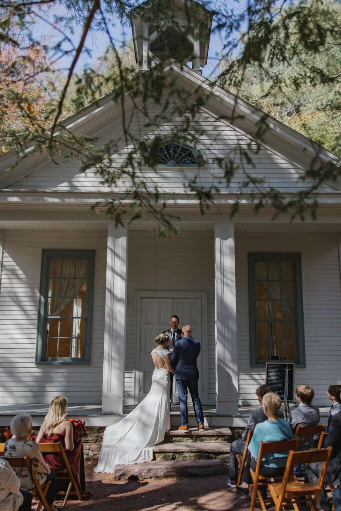 A bride and groom stand on the steps of the chapel at Hickory Run State Park during their intimate wedding
