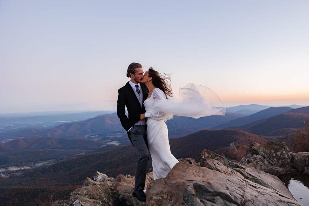 A bride and groom kiss on top of Stony Man during their sunrise elopement.