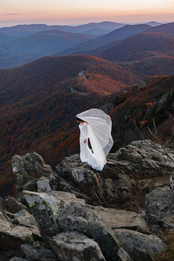 A bride and her veil standing on Stony Man Summit at sunrise