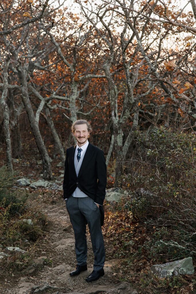 A photo of a groom wearing his 3 piece suit with tails. 