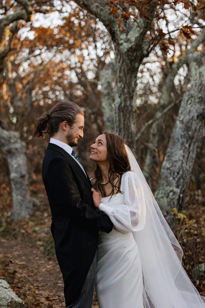 A bride and groom smile at one another during their elopement celebration