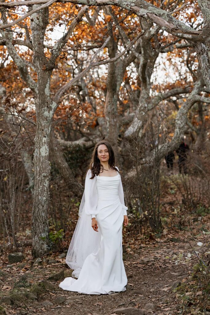 A portrait of a bride wearing a silk dress with sheer long sleeves