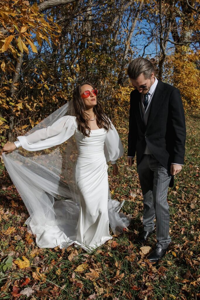 A bride and groom wearing sunglasses in the yellow foliage of Shenandoah National Park