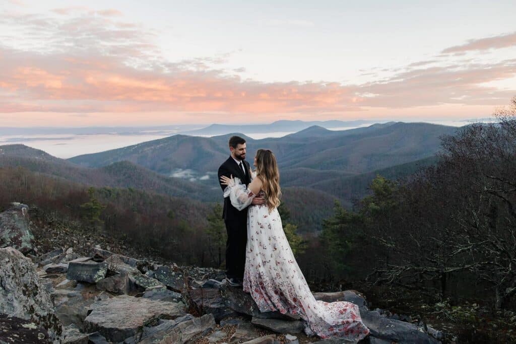 A bride and groom stand at Blackrock Summit during their sunrise elopement