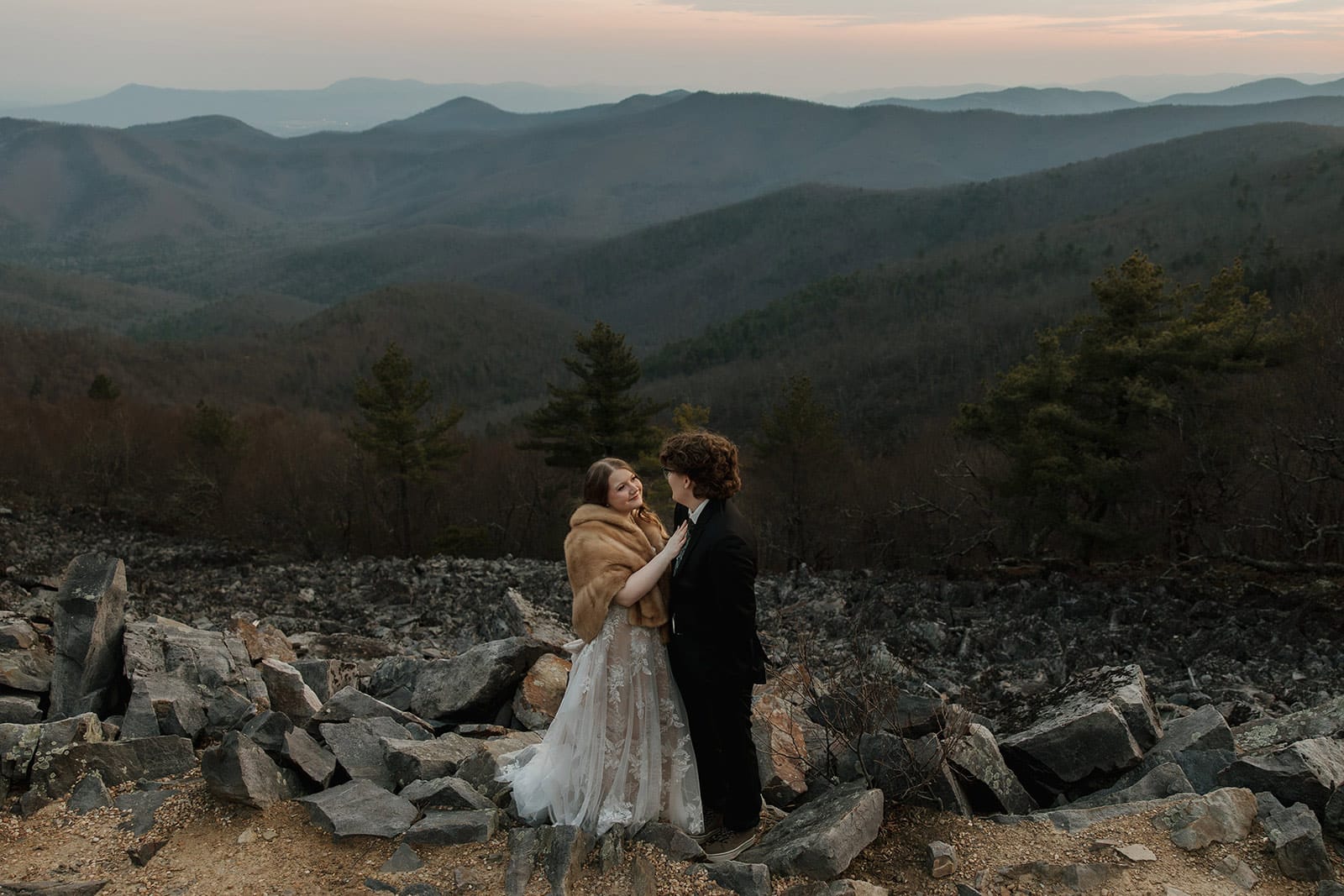 A bride and groom standing at Blackrock Summit during their sunrise elopement at Shenandoah National Park