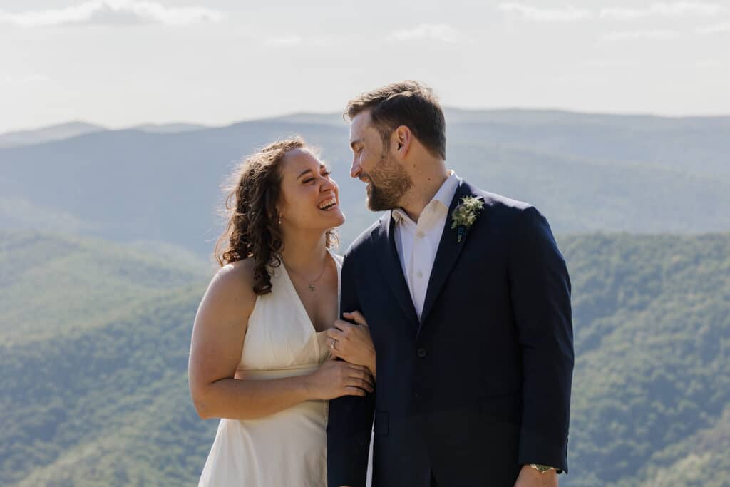 A bride and groom smile at one another during their intimate elopement at Raven's Roost in Virginia