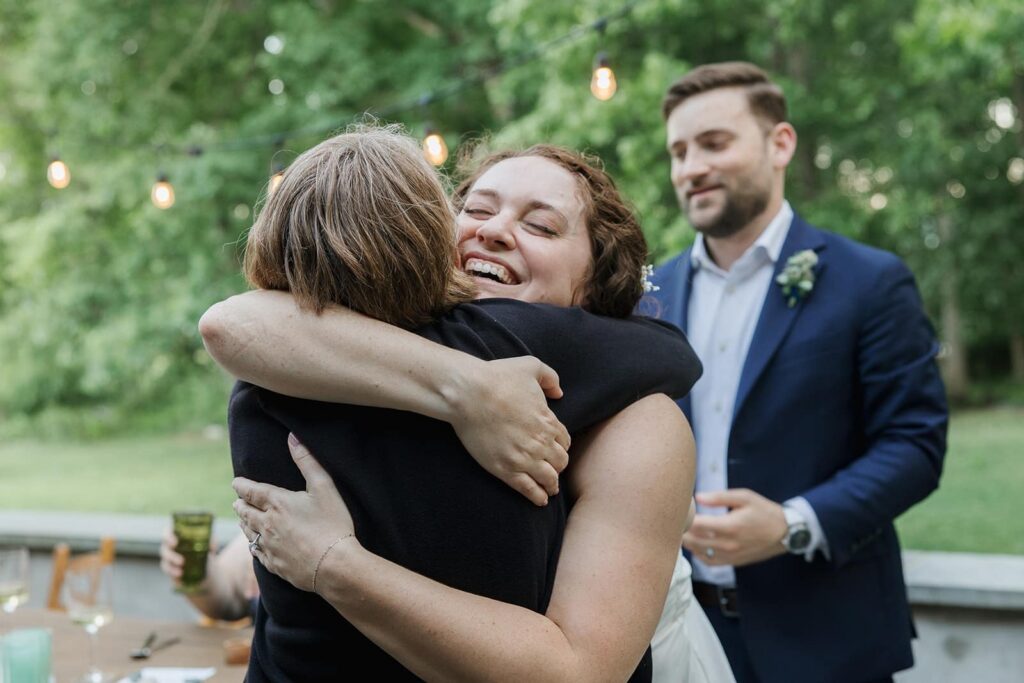 A bride hugs her mother after her moms gave a toast to her and her husband during the dinner at their intimate wedding in Virginiai