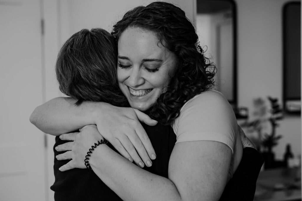 A bride hugs her mother before she gets dressed on her wedding day