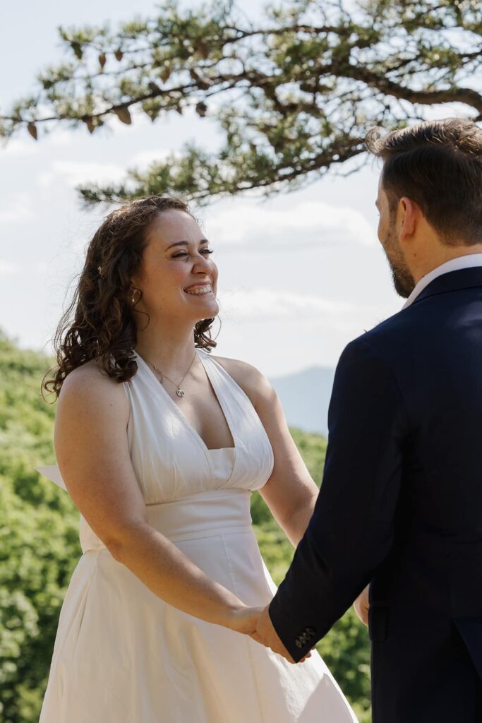 A bride looks at her groom during the vows of their allotment ceremony at Raven's roost