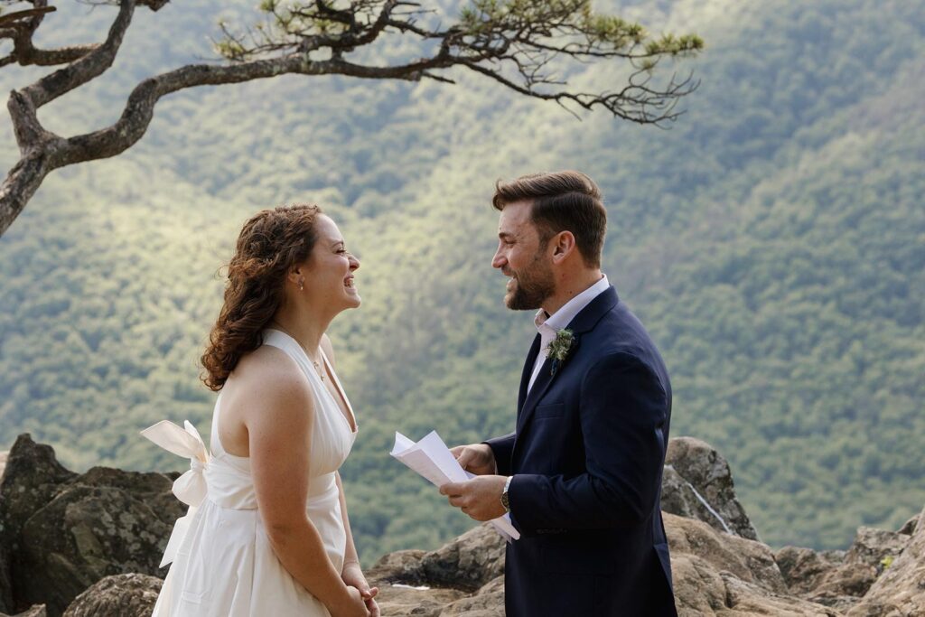 A bride laughs as her groom reads her his vows during their intimate development with family in Virginia

