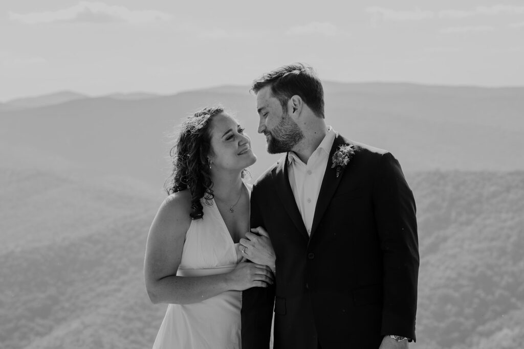 A bride holds onto her grooms arm as they exchange smiles during their Virginia elopement