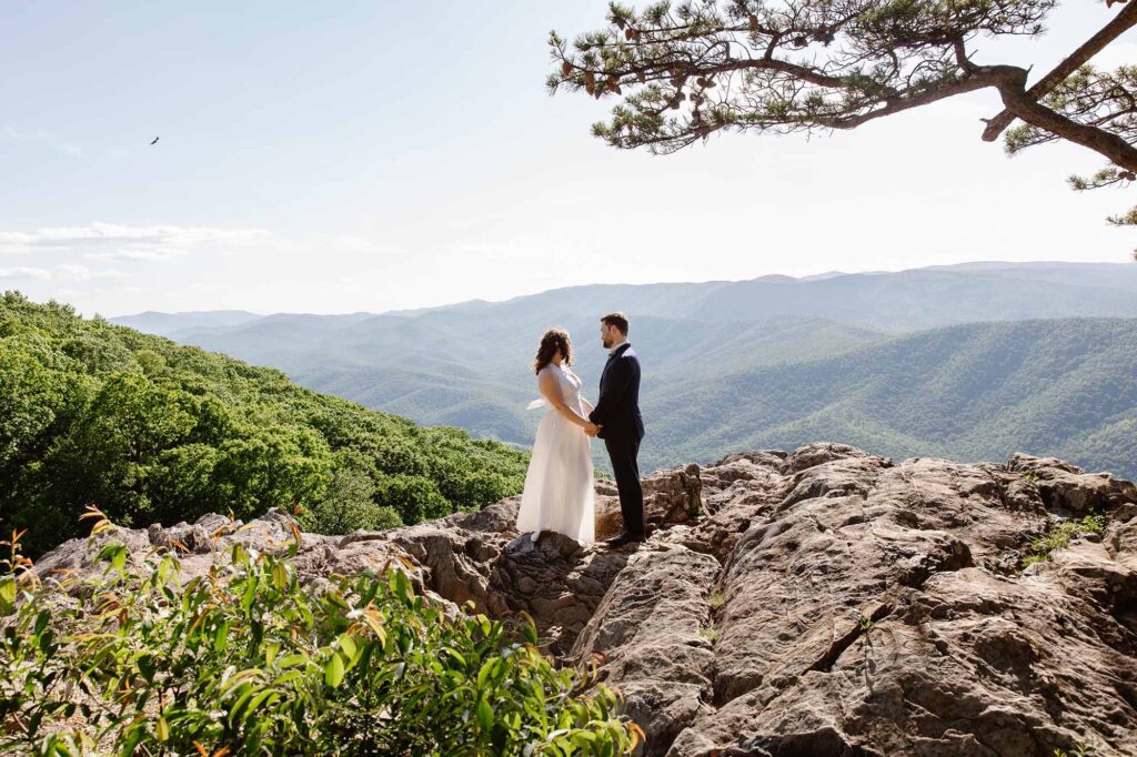 A bride and groom hold hands at an overlook in Virginia during their allotment ceremony