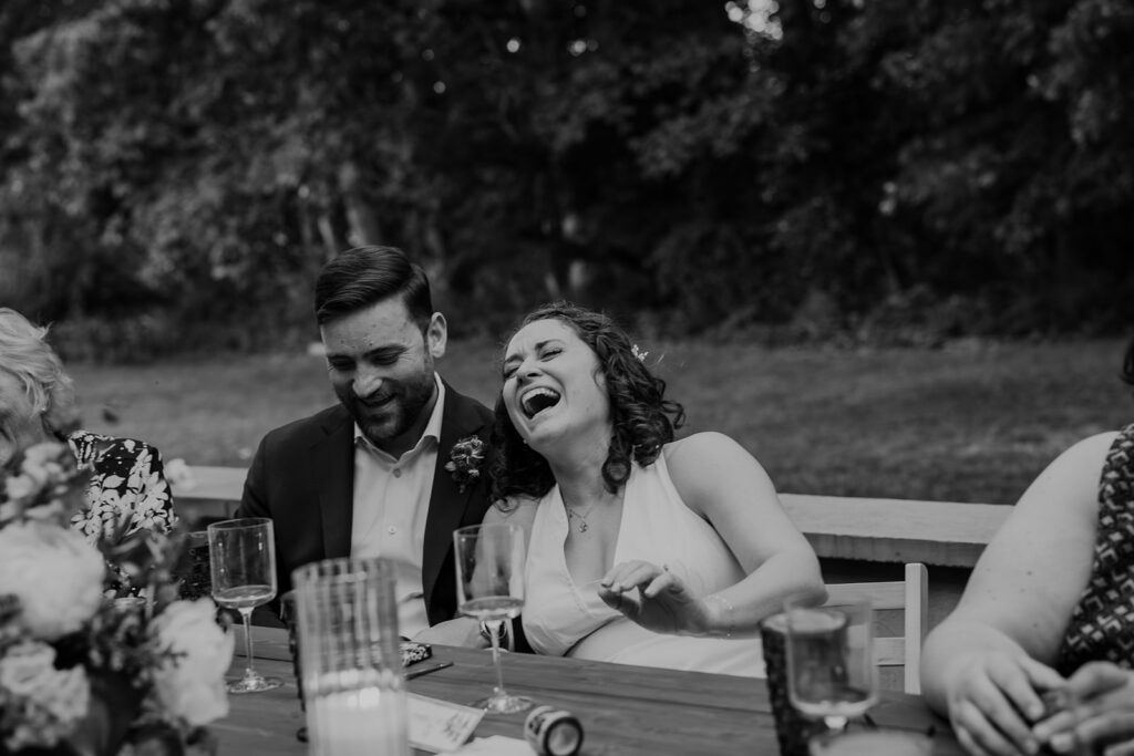 A bride laughed hysterically during a toast at her intimate wedding reception at indigo house in Virginia