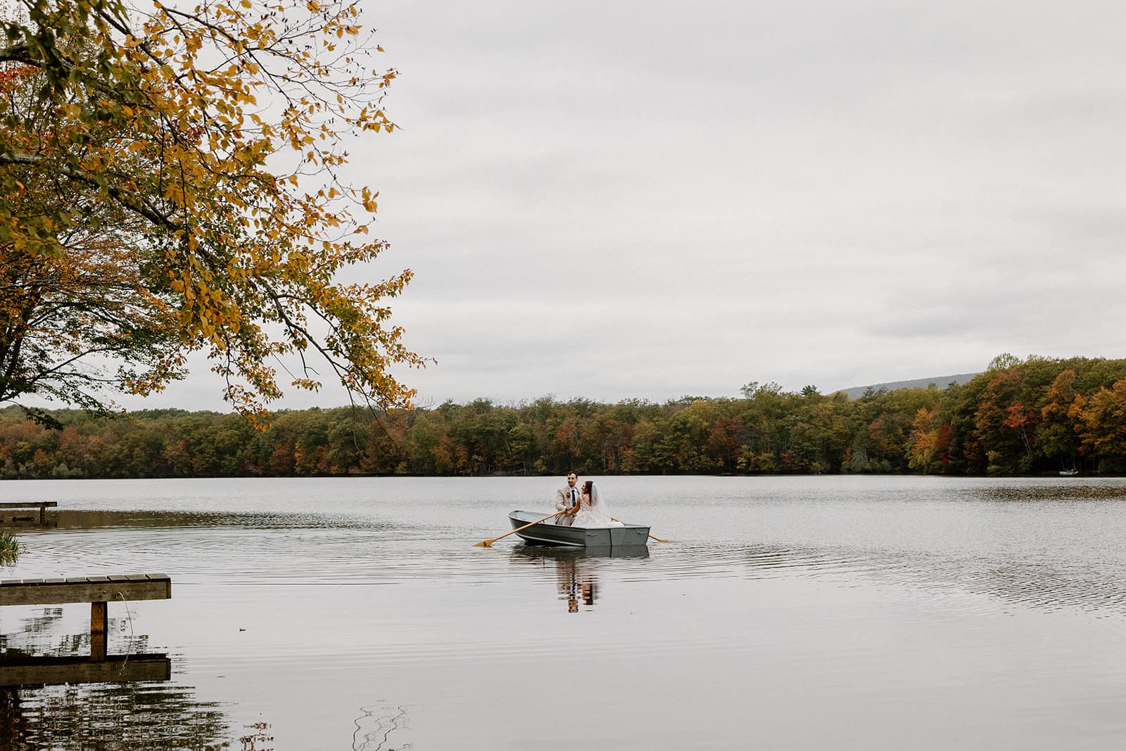 A bride and groom take a romantic canoe ride across the lake during their full-day elopement