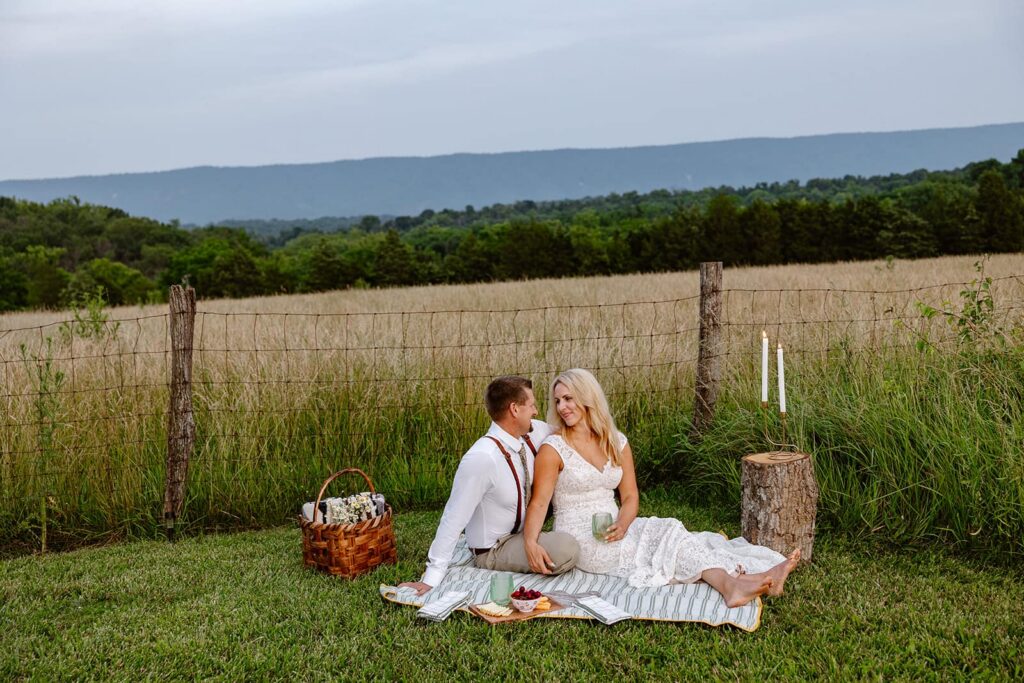A bride and groom sit and enjoy a picnic dinner during a chill part of their full day elopement